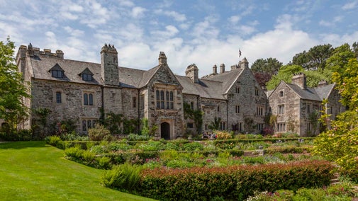 A view of the front of the house and garden at Cotehele on a sunny day, Cornwall